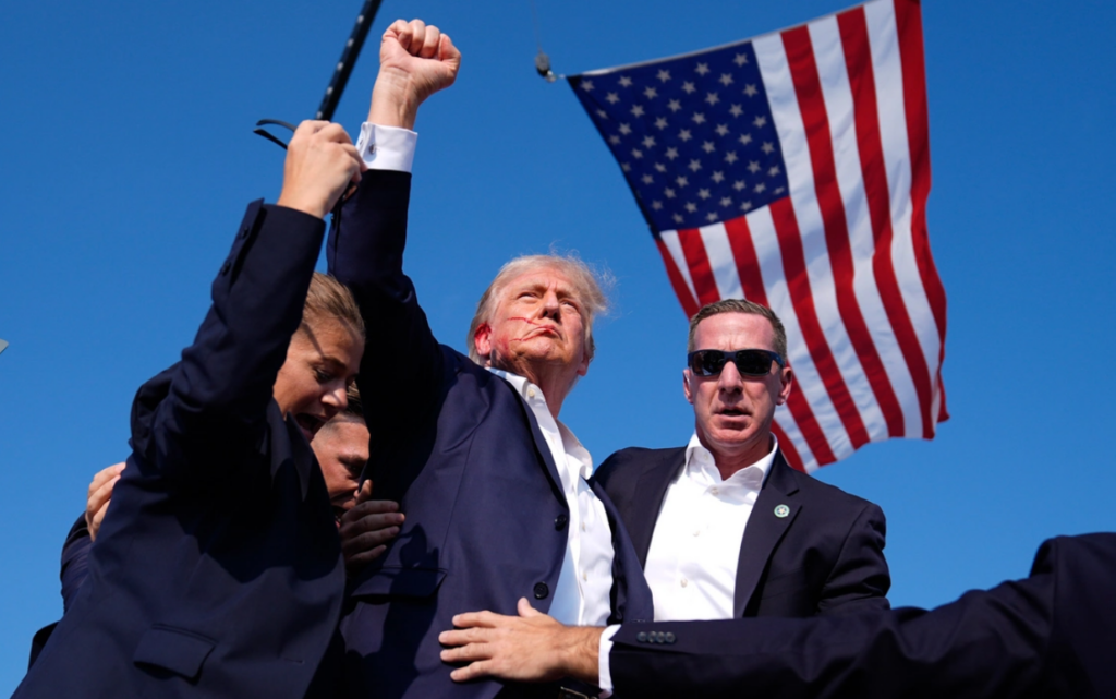 President Trump raises his fist after an assassin's bullet grazed his ear in Butler, PA, July 13, 2024.