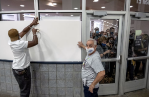 Poll workers in the ballot counting operation cover up windows to block protesters.Seth Herald / AFP via Getty Images file